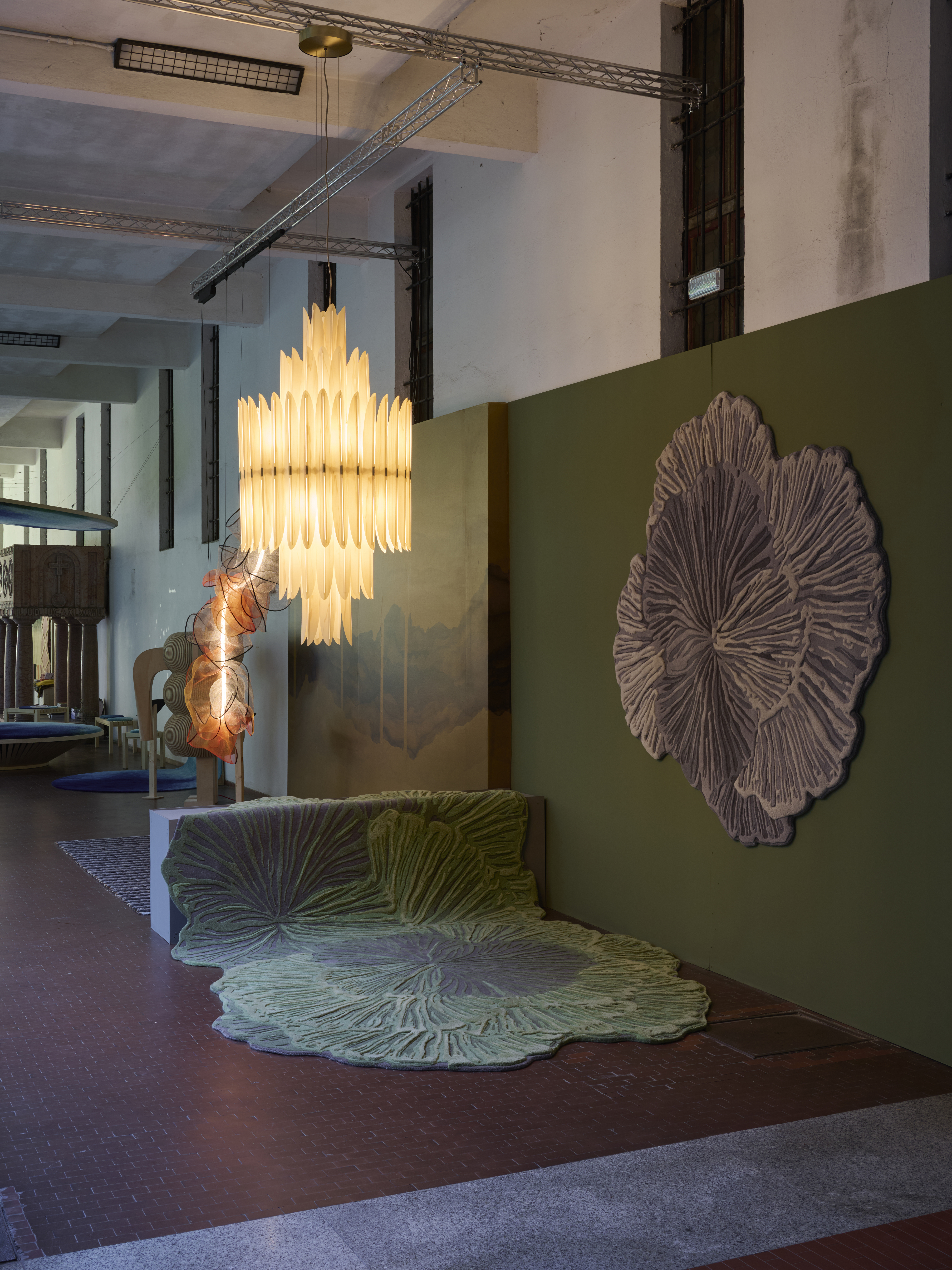 This picture shows the Voliere lamp hanging in front of a mural designed by Bodo Sperlein and above rugs also by the designer for the company Gan Rugs.